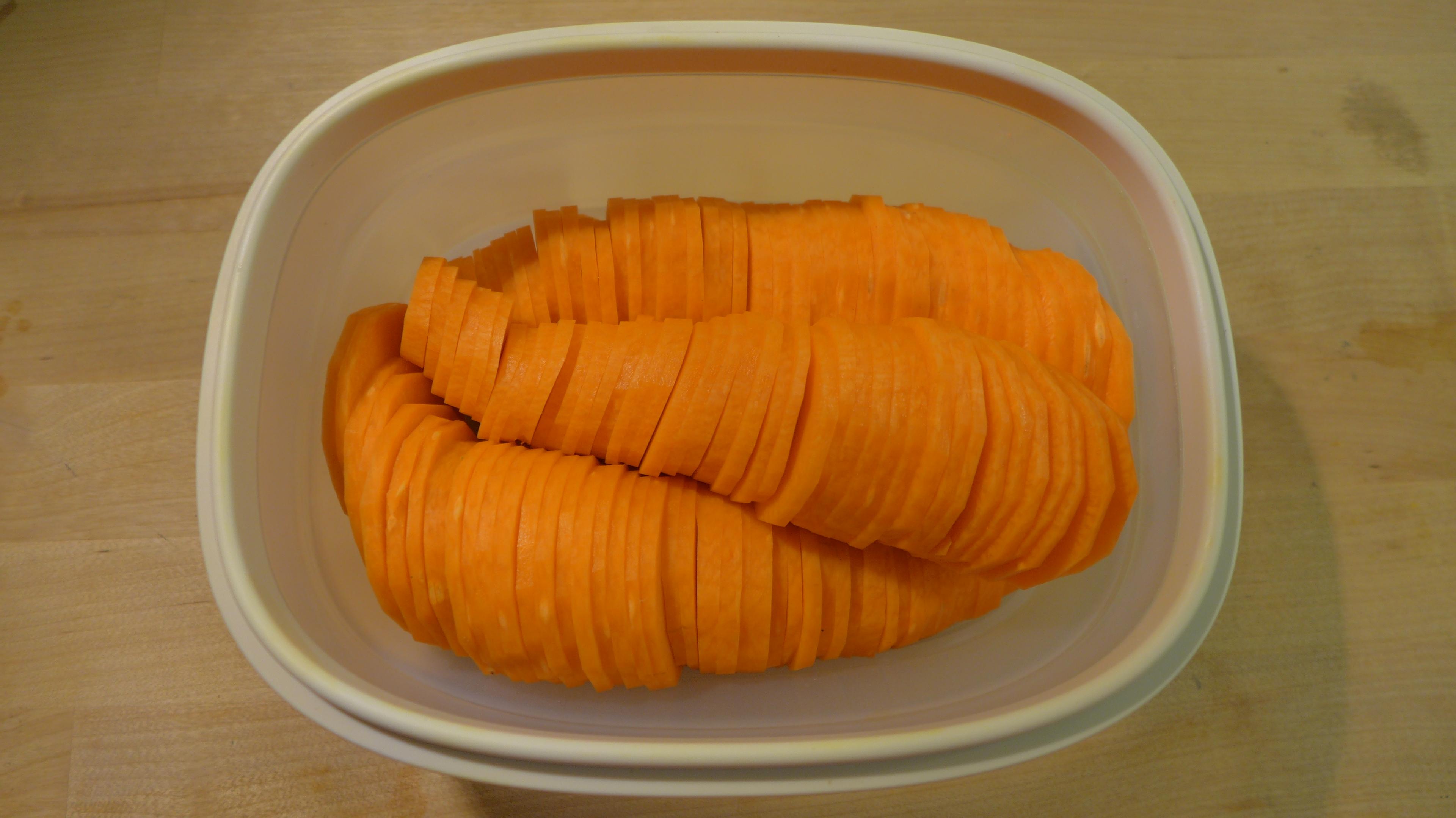 保鮮盒裡裝著三根切成片但擺放成幾乎維持原狀的紅蘿蔔