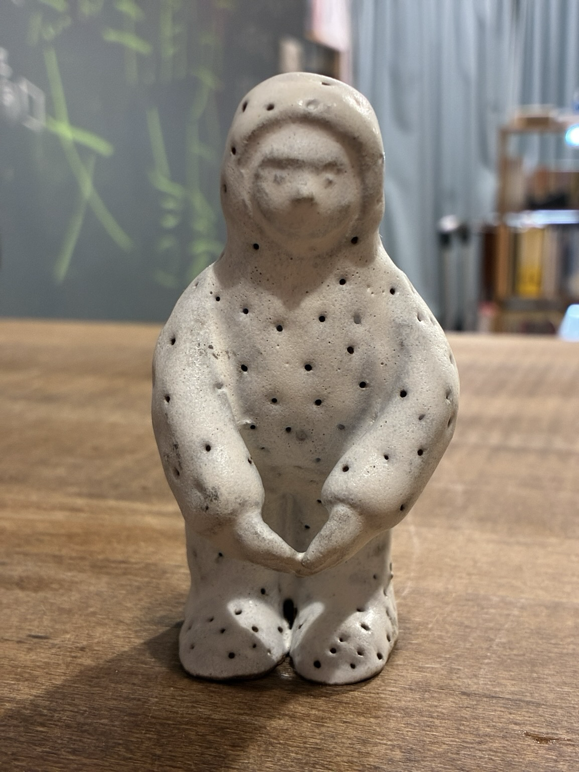 A mushroom man with his fingertips touched together. The Front side.